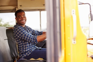 School bus driver sitting behind the wheel.